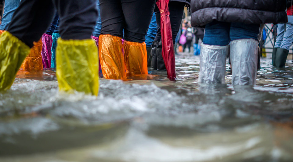 people walking in flood waters