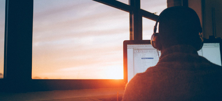 man near window with laptop