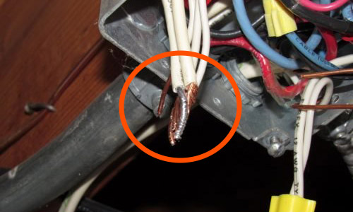An aluminum wire mixed with copper wiring coming out of an electrical box.