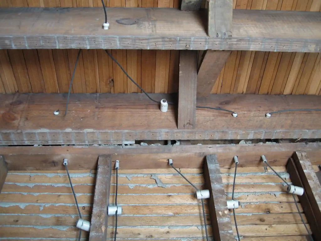 Ceiling of a house showing knob and tube wiring installed throughout.