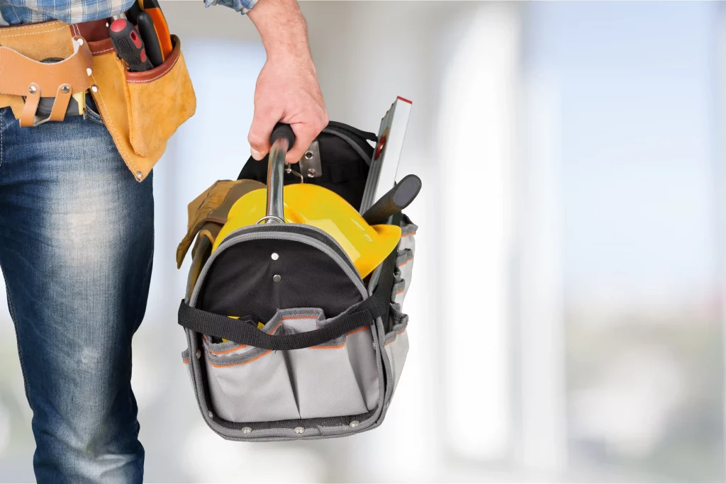 Close up of a workers hand holding a tool bag.