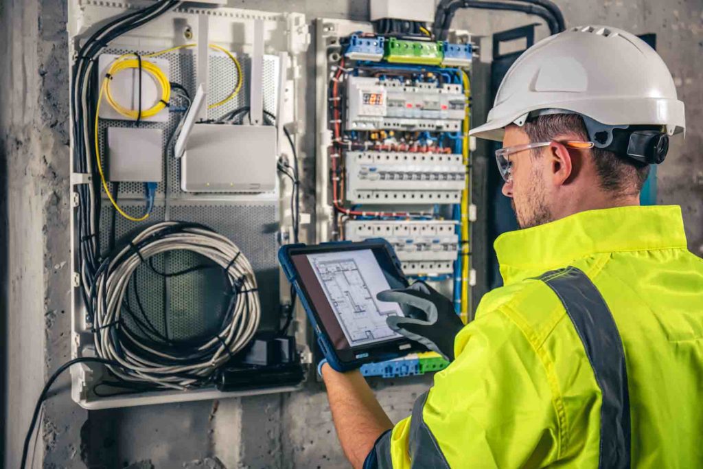 An electrician inspecting and electrical panel.
